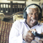 A man smiles while playing a video game.