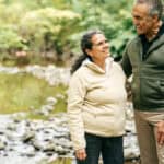 Two seniors walk in the forest