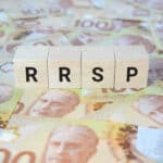 RRSP (Registered Retirement Savings Plan) on wooden blocks and Canadian one hundred dollar bills.