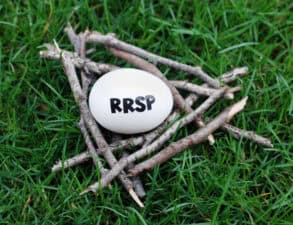 Close up of an egg in a nest of twigs on grass with RRSP written on it symbolizing a RRSP contribution.