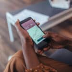 Person holding a smartphone with a stock chart on screen