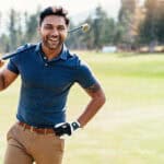 Happy golf player walks the course