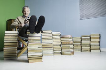 a man relaxes with his feet on a pile of books