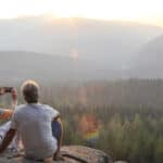 people relax on mountain ledge