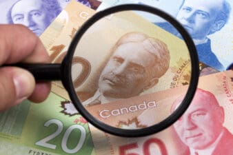 Canadian dollars in a magnifying glass