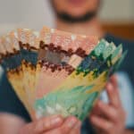 Man holds Canadian dollars in differing amounts