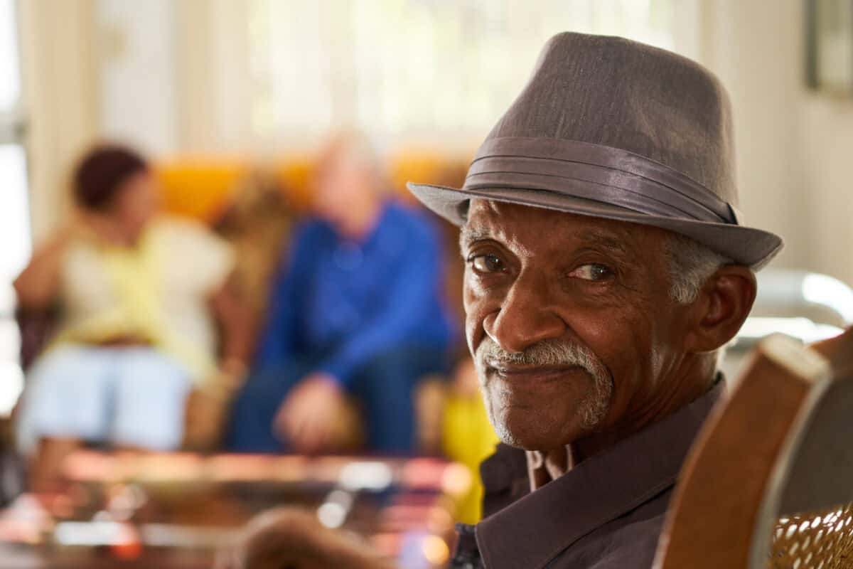 Man in fedora smiles into camera