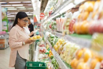 shopper chooses vegetables at grocery store