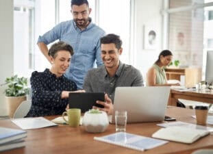 GettyImages-three smiling investors_using tablet